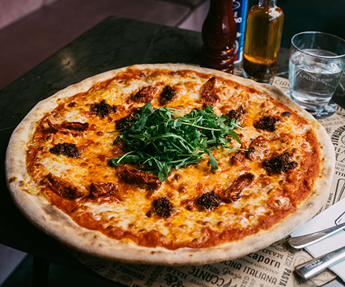 Unsere Pizza Nduja Calabrese auf einem schönen Holztisch